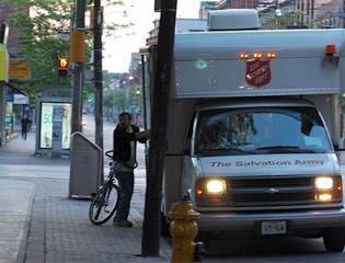 The Salvation Army truck and a man on bike beside it